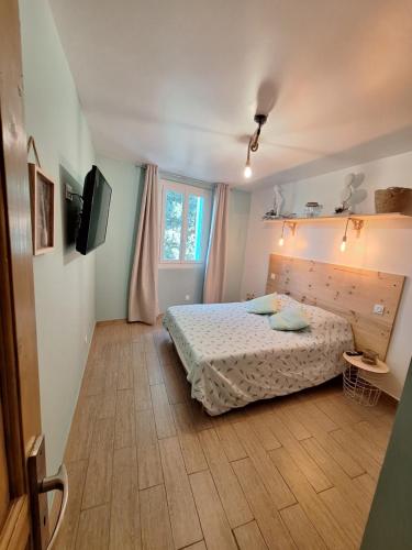une chambre avec un lit et une télévision dans l'établissement Charmant Appartement paisible à 5 mn en voiture de la plage, à Canet