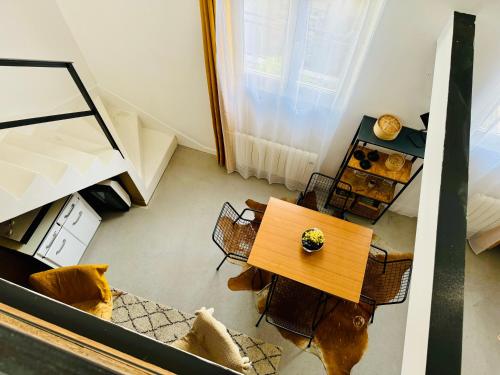une vue aérienne d'un salon avec une table et des chaises dans l'établissement Charmant duplex centre ville, à Pantin