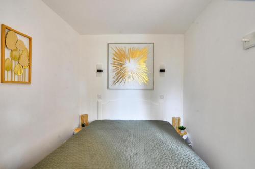 une chambre avec un lit et un tableau au mur dans l'établissement La résidence du Lac - maeva Home - Appartement avec terrasse et parking 2 pièces 4 personnes - Prestige - super Home MAE-6811, à Monflanquin