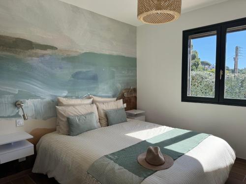une chambre avec un lit avec un chapeau dessus dans l'établissement L'appartement Porquerolles au Lavandou, au Lavandou