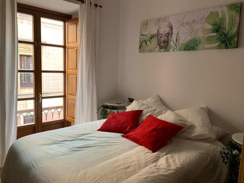 a bedroom with a bed with two red pillows at MyHouseSpain - Acogedor apartamento plaza mayor Gijón 1 in Gijón