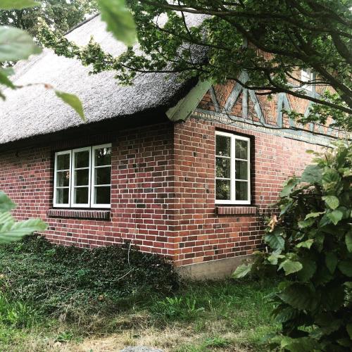 a brick building with two windows and a roof at Elbkoje in Drage