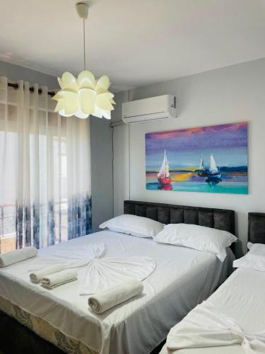 una camera da letto con due letti e un quadro sulla parete di Boat Apartment a Durrës