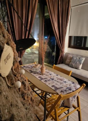 a dining table and chairs in a living room at To Palio Kamini in Velanídhia