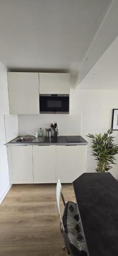 une cuisine blanche avec un évier et une table dans l'établissement Seaside Chic, à Deauville