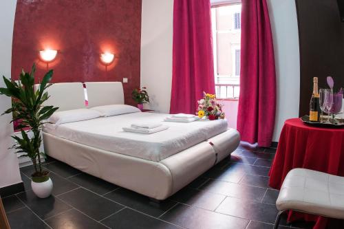 1 dormitorio con cama blanca y cortinas rojas en Gio' Suites, en Roma