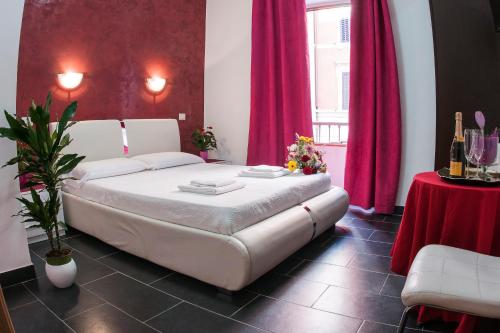 Un dormitorio con una cama blanca y cortinas rojas. en Gio' Suites, en Roma