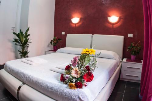 a bedroom with a bed with a flower arrangement on it at Gio' Suites in Rome