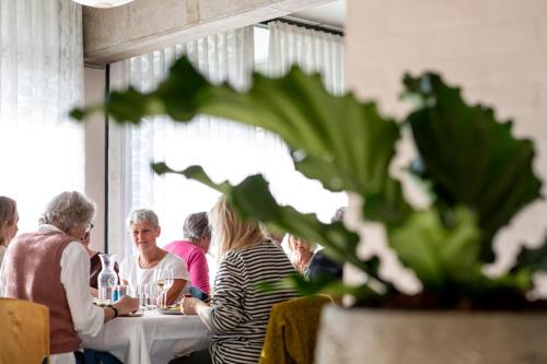 um grupo de pessoas sentadas numa mesa num restaurante em Toppen af Ebeltoft em Ebeltoft