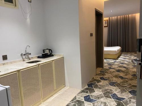 um quarto de hotel com um lavatório e uma casa de banho em كيان ألين em Abha