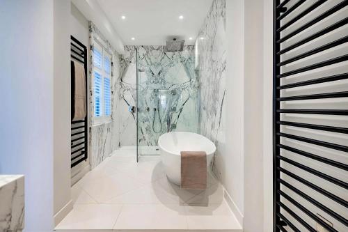 a bathroom with a toilet and a glass shower at Welcome London - Trafalgar Townhouse in London