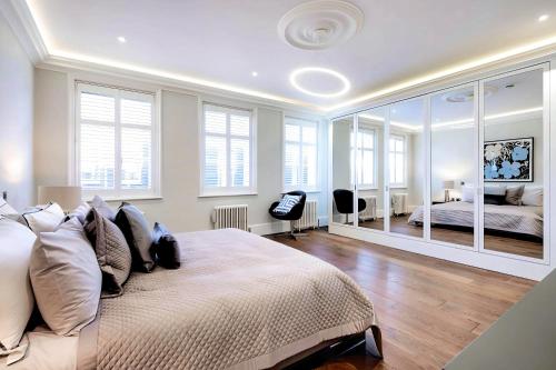 a bedroom with a large bed with a large mirror at Welcome London - Trafalgar Townhouse in London