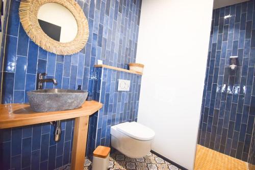 a blue tiled bathroom with a sink and a toilet at Appartement vue montagnes - MENDIBIL in Zugarramurdi