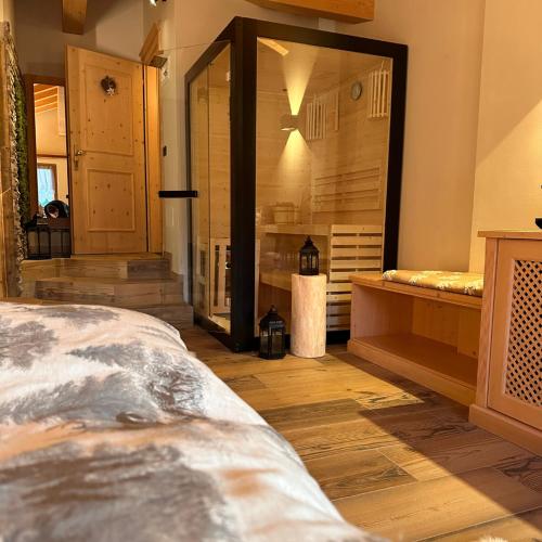 a bedroom with a large mirror and wooden floors at Rifugio Caltena in Fiera di Primiero