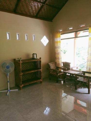 a living room with a fan and a window at Ridho's Homestay & Jungle Trekking in Bukit Lawang