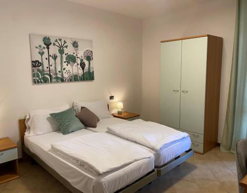 1 dormitorio con 1 cama blanca y armario en Ca' ai Tigli en Tignale