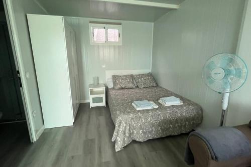 una piccola camera con letto e ventilatore di Renovated Tiny House a San Bartolomé