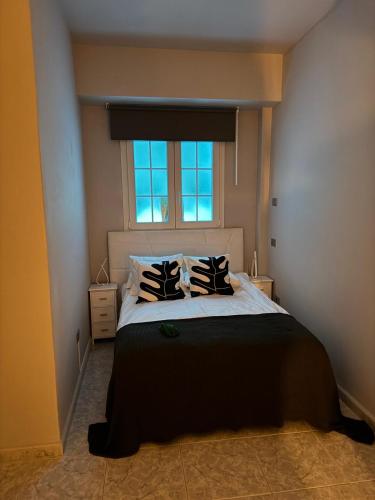 a bedroom with a bed with pillows and a window at Basement Apartment Studio in San Bartolomé