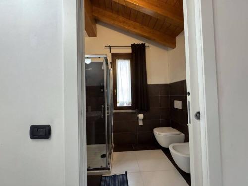 ein Bad mit einem WC und einer Glasdusche in der Unterkunft Comfort Room 4 Dogana Svizzera in San Fermo della Battaglia