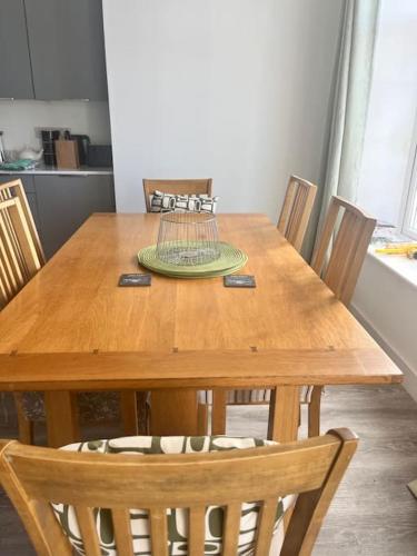 a wooden table with chairs and a bird cage on it at Trearddur Bay ground floor apartment in Trearddur