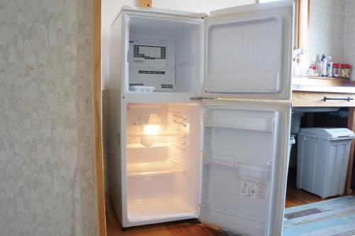 um frigorífico com a sua porta aberta numa cozinha em 源泉掛け流しの温泉宿 Oyado-Kikiairaku お宿 喜喜哀楽 #IG2 em Ito