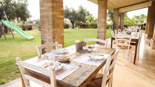 a wooden table with white chairs and a playground at Bio Agriturismo Poggio Aione in Saturnia