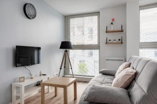 un salon avec un canapé et une télévision dans l'établissement Appartement Luce - Welkeys, à Lille