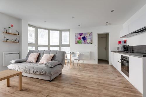 un salon avec un canapé et une cuisine dans l'établissement Appartement Luce - Welkeys, à Lille