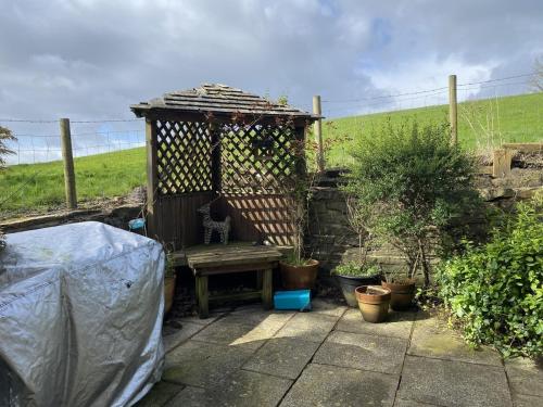 eine Holzbank in einem Garten mit Pflanzen in der Unterkunft Little Cottage - A Peaceful 3BD Retreat for 5 in Chorley