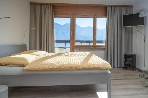 a bedroom with a bed with a view of the mountains at Ferienwohnungen Zurschmitten in Riederalp