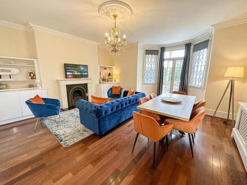 a living room with a blue couch and a table at Stunning 3BR Apt Retreat on River Thames l 5Bd2Bth in London