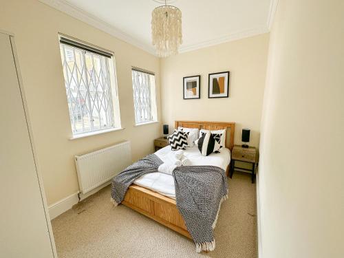 a bedroom with a bed and a chandelier at Stunning 3BR Apt Retreat on River Thames l 5Bd2Bth in London