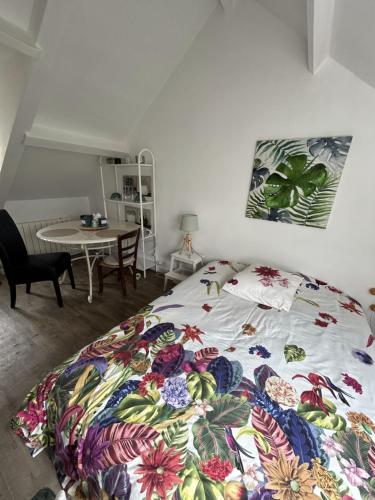 a bedroom with a bed with a colorful blanket at Le cocon jaune - Studio en hyper centre in Lamballe