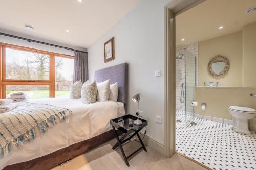a bedroom with a large bed and a bathroom at Raynham Breck in Colkirk
