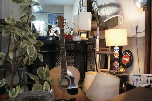 a guitar sitting in a room with a plant at IG2 源泉掛け流し温泉付きの宇佐美貸切宿 お宿 喜喜哀楽 Oyado Kikiairaku in Ito