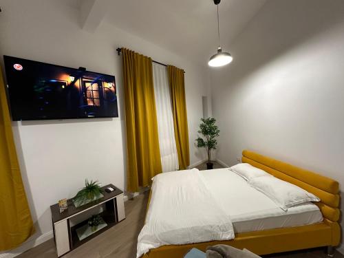 Schlafzimmer mit einem Bett und einem Flachbild-TV in der Unterkunft Bucharest City Center Villa in Bukarest