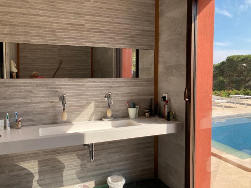 une salle de bains avec deux lavabos et une piscine dans l'établissement Villa Vue Mer, à Sainte-Maxime