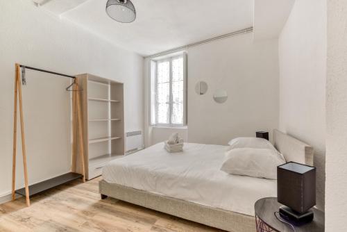 une chambre blanche avec un lit et une fenêtre dans l'établissement Ò Grand Carnot/Hyper centre/Proche Gare, à Carcassonne