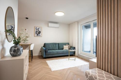 a living room with a blue couch and a table at KOBIELA APARTMENTS Dębowe Tarasy in Katowice