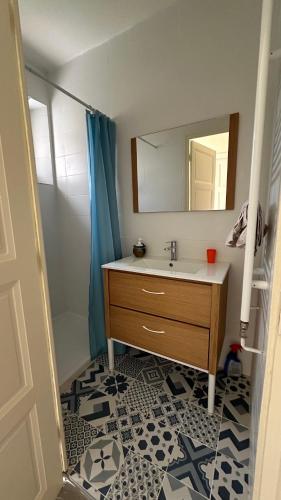 une salle de bain avec un lavabo et un miroir dans l'établissement Gîte Maison Fougères droite Saint-Préjet d'Allier 14 personnes, à Saint-Préjet-dʼAllier