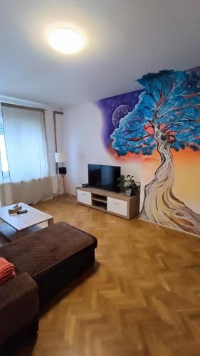 a living room with a tree mural on the wall at Moon Tree *** in Varaždin
