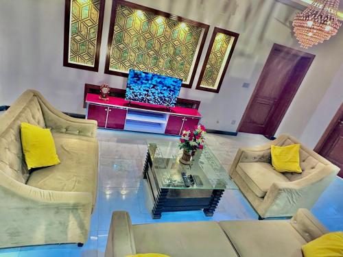 a living room with two chairs and a glass table at Homely Guest House and Hotels in Islamabad, Bahria Rawalpindi in Rawalpindi