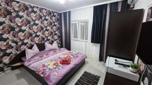 a bedroom with a purple bed with flowers on it at Casa Sebastian in Costinesti