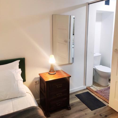 a bedroom with a bed and a lamp on a dresser at Imaculada Home Royal - Centro de Braga, Historico in Braga