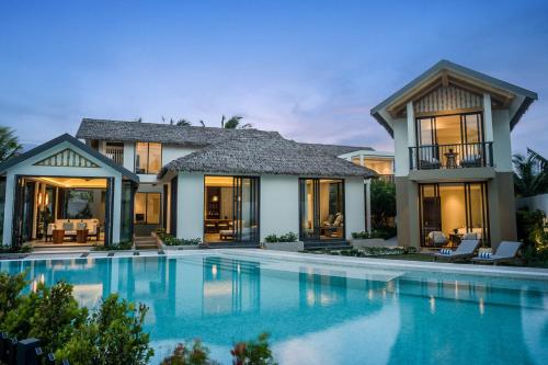 uma villa com piscina ao anoitecer em New World Phu Quoc Resort em Phu Quoc