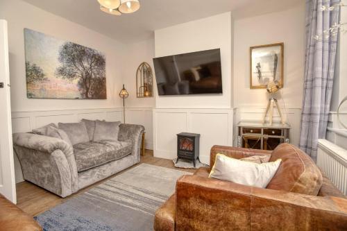 a living room with two couches and a tv at Cosy Countryside Hideout - Pass the Keys in Whisby