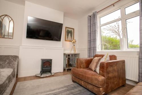a living room with a couch and a fire place at Cosy Countryside Hideout - Pass the Keys in Whisby