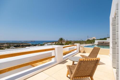 a balcony with chairs and a view of the ocean at Anna Platanou Suites in Agia Irini Paros