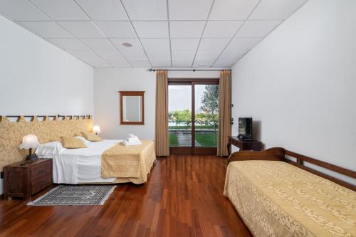 a large bedroom with a bed and a window at Locanda Da Vittorio in Manerba del Garda