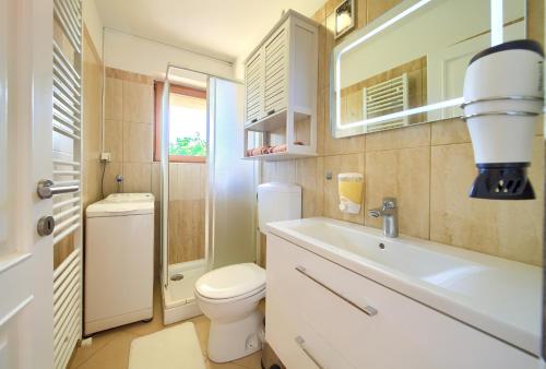 ein Badezimmer mit einem WC, einem Waschbecken und einem Spiegel in der Unterkunft Apartman Meri in Krk